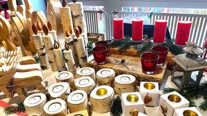 Verkaufsstand mit zahlreichen Kerzen und Holzdekorationen des Weihnachtsbasars des SRH Bildungscampus Neckargemünd.